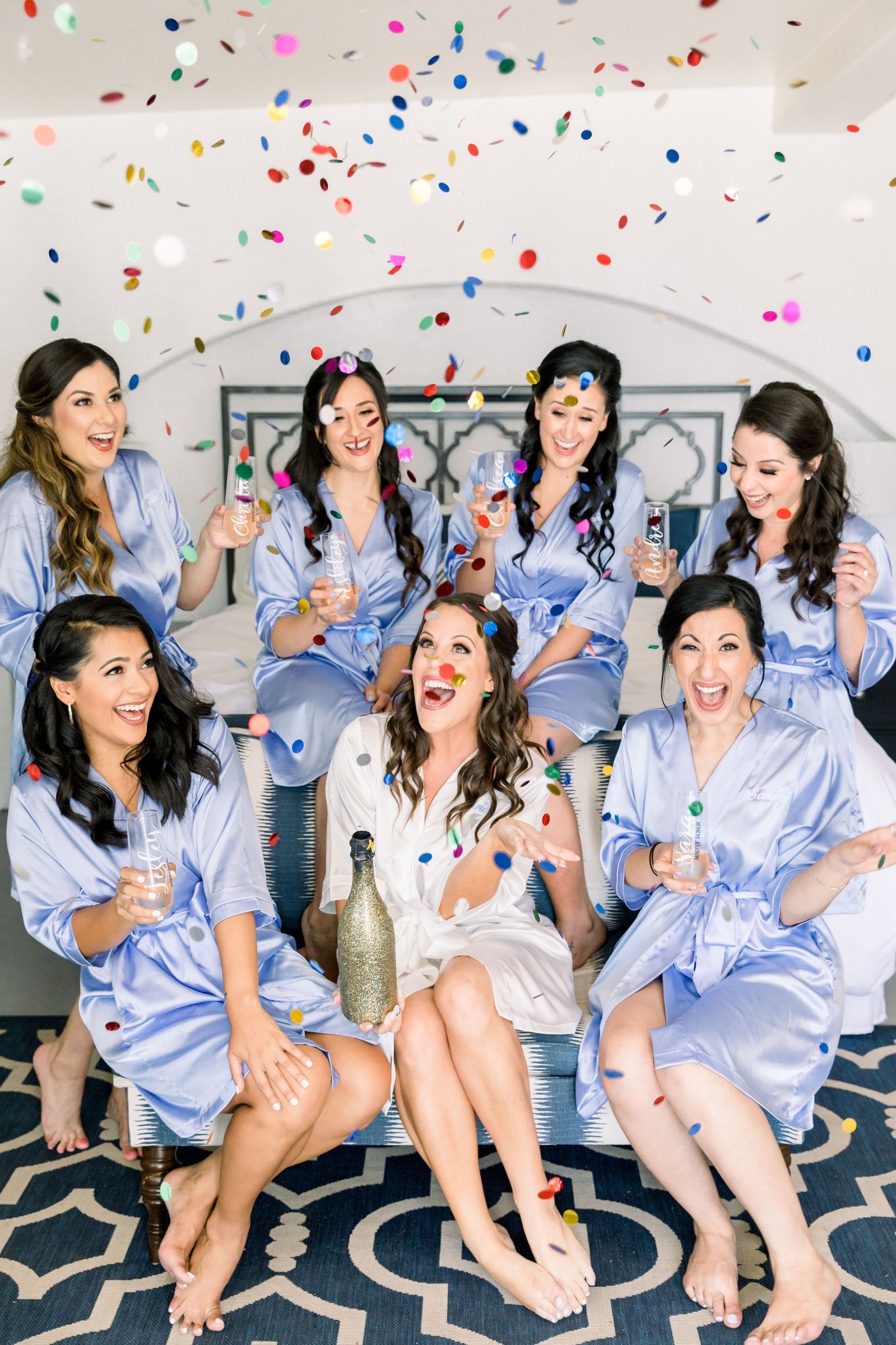 Bride and her bridesmaids popping champagne