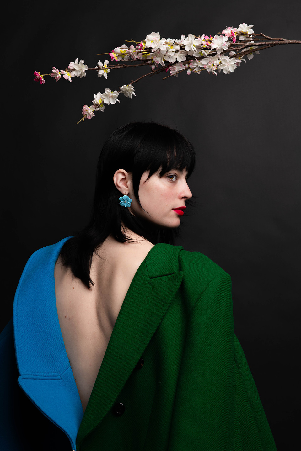 Woman with colourful coats under a cherry blossom tree. Editorial photography, headshot photography, model photography, editorial pictures.