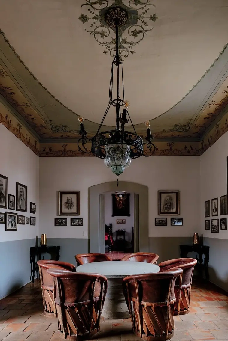 In the living room of the architect Rafael Urzúa Arias’s home in Concepción de Buenos Aires, Mexico, family photos line the walls and traditional equipal chairs from Zacoalco de Torres sit around a cement and Cantera San Andrés stone table. 