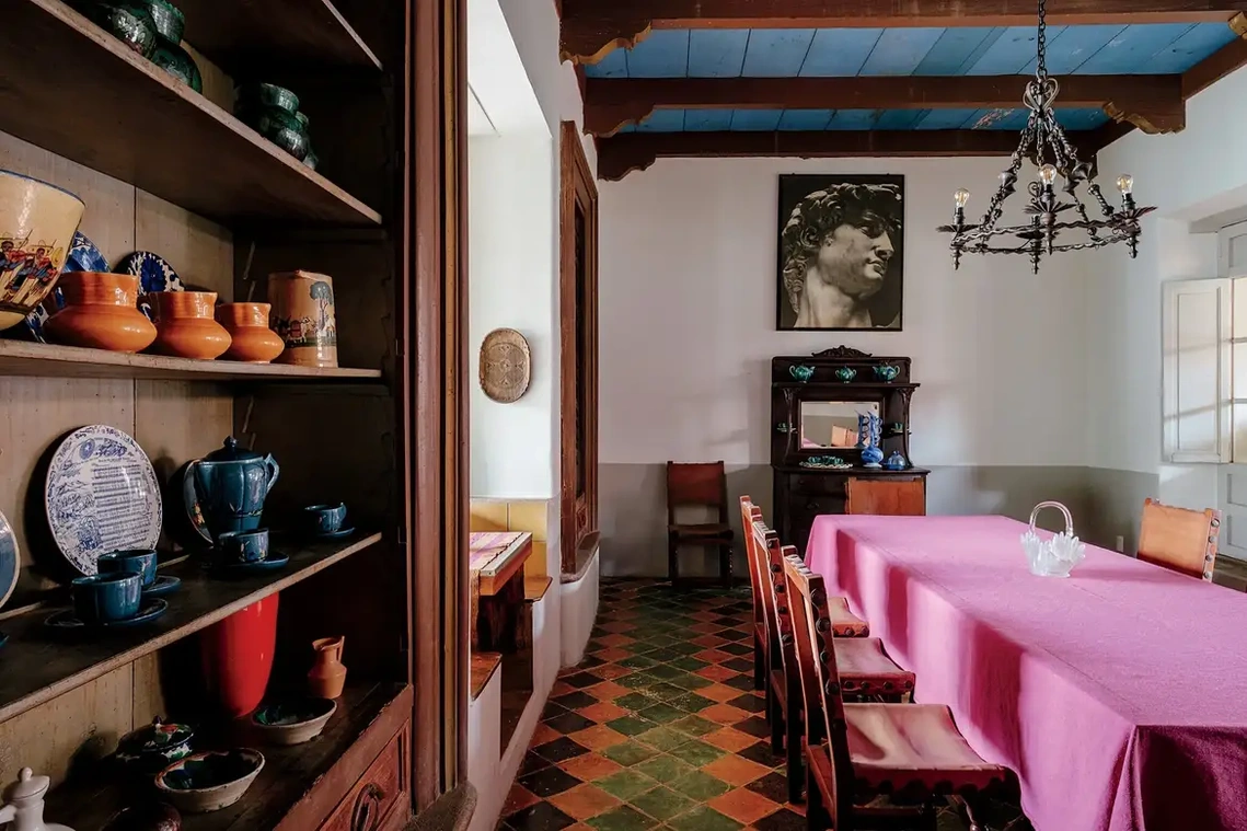 In the dining room, a photograph of Michelangelo’s “David” hangs over a table covered in a pink cotton tablecloth designed by Estudio Pomelo and handwoven on a pedal loom in Oaxaca. The floor is made of early 20th-century vitrified clay tiles.