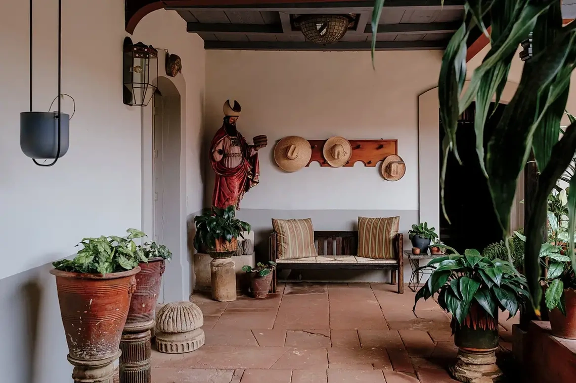 In one of the corridors on the main patio, clay pots, a wooden sculpture of Melchizedek and an early 20th-century wood and woven palm bench. Credit Ana Topoleanu