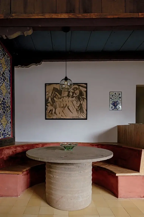In the old kitchen, Urzúa created a dining nook with a banquette and a cement and Cantera San Andrés stone table. A photographic reproduction of a José Clemente Orozco drawing was a gift by the artist to Urzúa. Credit Ana Topoleanu