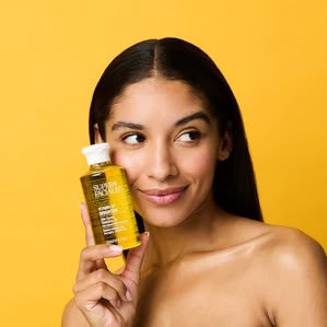 Brunette model holding Superfacialist Vit C Cleansing oil. Photographed and styled by cosmetic photographer Tom Hargreaves in his studio in Exeter, Devon