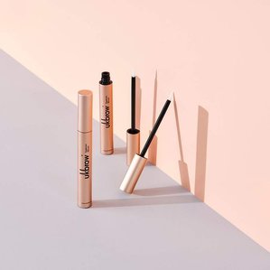 UKlash eyebrow serums standing and leaning on grey and nude pink backdrop creating strong angled shadows. Photographed and styled by cosmetic photographer Tom Hargreaves in his studio in Exeter, Devon