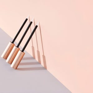3 UKlash eyebrow serum brushes leaning against wall creating strong shadows. Photographed and styled by cosmetic photographer Tom Hargreaves in his studio in Exeter, Devon