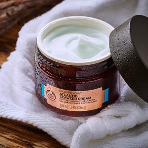 The Bodyshop Atlantic Seaweed cream with lid off showing styled swirling product in side in spa type setting. Photographed and styled by cosmetic photographer Tom Hargreaves in his studio in Exeter, Devon