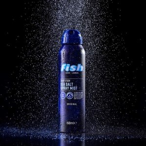Fish Soho sea salt spray mist can with sea salt spraying down from above onto the product with black background. Photographed and styled by cosmetic photographer Tom Hargreaves in his studio in Exeter, Devon