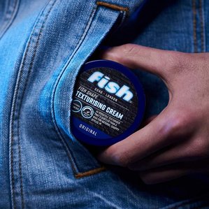 Fish soho texturising cream being pulled out of male models denim jacket pocket.
Photographed by Tom Hargreaves in a London studio