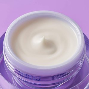 Face cream styled and whipped into a circular pattern in its pot with lid off,  A cosmetic styled product photograph shot in Tom Hargreaves studio in Exeter Devon