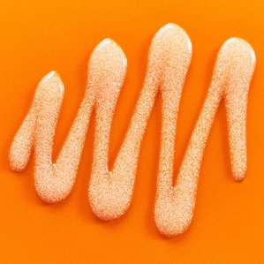 Closeup of Superfacialist micro polish wash swatch on an orange backdrop. Photographed and styled by cosmetic photographer Tom Hargreaves in his studio in Exeter, Devon
