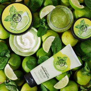 The Bodyshop Mojito range of body cream, scrub and sorbet. Lying on a bed of fresh limes and mint. Photographed and styled by Tom Hargreaves in Exeter, Devon