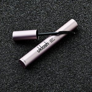 UKlash volume boost mascara lying on black sand. Photographed and styled by cosmetic photographer Tom Hargreaves in his studio in Exeter, Devon