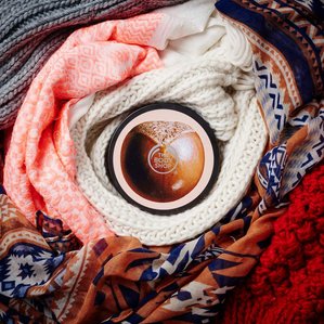 The Bodyshop shea body butter wrapped in warm scarves. Photographed and styled by cosmetic photographer Tom Hargreaves in his studio in Exeter, Devon