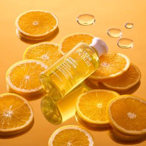 Superfacialist Vitamin C skin renewing cleansing oil lying on a bed of orange slices on mirror. Photographed and styled by cosmetic photographer Tom Hargreaves in his studio in Exeter, Devon