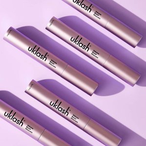 multiple UKlash volume boost mascaras lying on violet background with strong shadows. Photographed and styled by cosmetic photographer Tom Hargreaves in his studio in Exeter, Devon