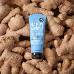 Happy Naturals revitalising foot scrub lying on a bed of ginger root. Photographed and styled by cosmetic photographer Tom Hargreaves in his studio in Exeter, Devon 