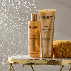 Argan+ Shine shampoo &amp;amp;amp; conditioner in shower setup with water dripping onto the products. Photographed and styled by cosmetic photographer Tom Hargreaves in his studio in Exeter, Devon