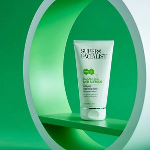 Superfacialist Salicylic acid anti blemish cleansing wash standing in circular white and green prop with green backdrop. Photographed and styled by cosmetic photographer Tom Hargreaves in his studio in Exeter, Devon