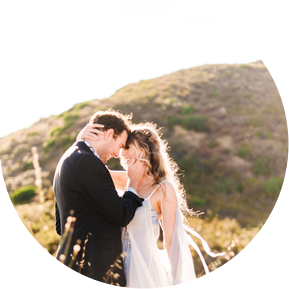 A bride and groom embrace in the golden hills of California
