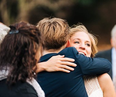 A bride at an intimate wedding hugs one of her guests