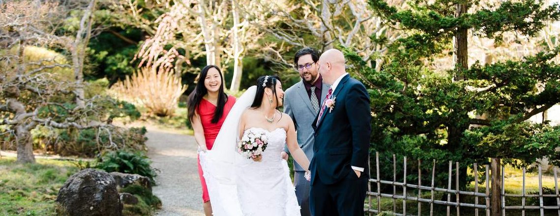 A bride and groom laugh and joke with their friends following their intimate wedding ceremony in a Japanese garden