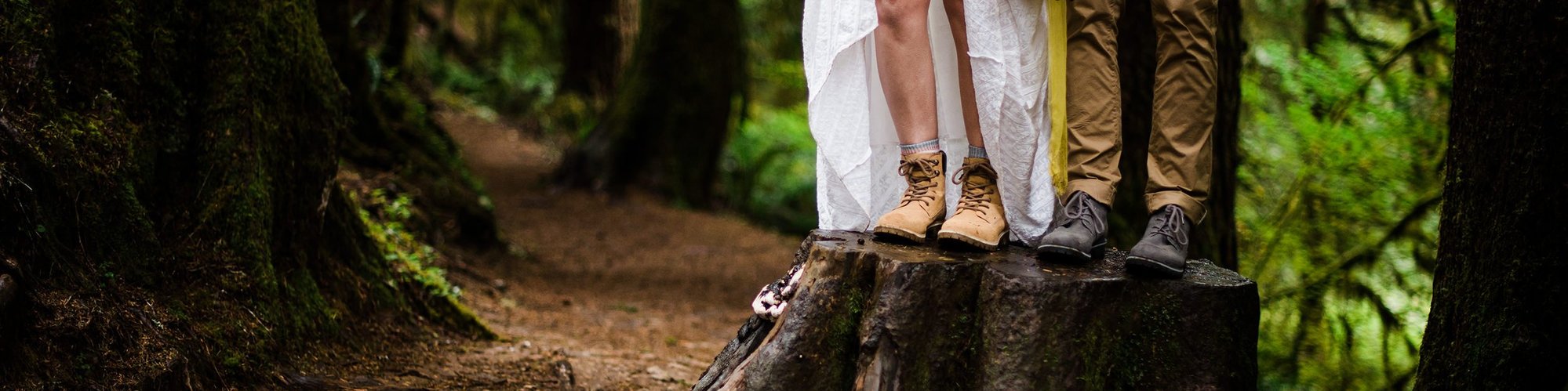 A bride and groom show off their hiking boots as they trek to their elopement ceremony location
