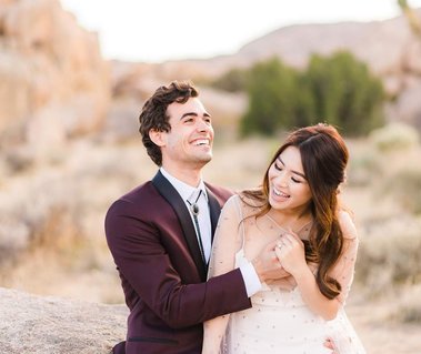 A bride and groom laugh and hug in the desert at Joshua Tree National Park