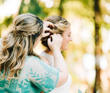 The Maid of Honor adjusts the bride's hair as she prepares for her wedding ceremony in the mountains