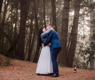 A bride and groom stop for an impromptu dance in the forest as they hike back to the trailhead from their elopement location