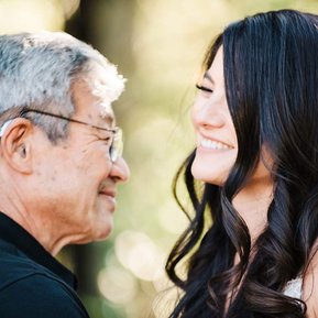 A bride and her father laugh during their father-daughter dance