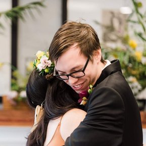 A bride and groom embrace at the end of their wedding ceremony