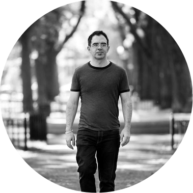 Black and white corporate portrait of a man, taken in a park