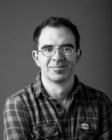 Black and white corporate portrait of a man, taken in studio