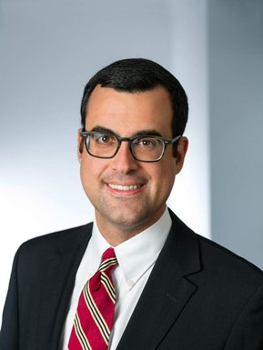 Portrait corporatif d'un dirigeant  d'un cabinet d'avocats souriant et portant un complet cravate