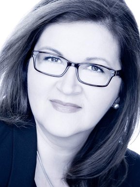 Individual corporate portrait of a woman, in black and white with a blue cast