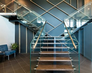 Photo architecturale intérieure dans le hall d'entrée d'une entreprise à Montréal, escalier de bois avec rampes de verre et mains courantes en bois
