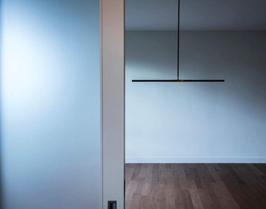 Porte coulissante de verre givré devant un luminaire suspendu au dessus d'une salle à manger