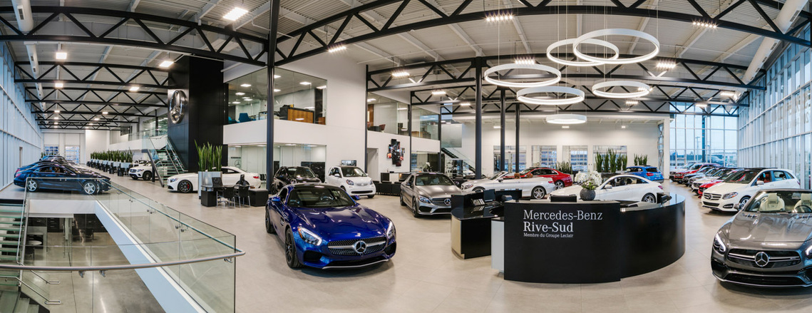 Photo panoramique du concessionnaire automobile Mercedes-Benz Rive-Sud, mettant en valeur toute sa salle de montre, l'escalier menant au sous-sol ainsi qu'un autre donnant accès à l'étage des bureaux