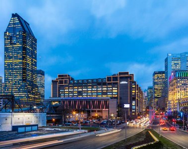 Photo d'architecture extérieure de la Place Bonaventure à Montréal, prise au crépuscule et montrant le boulevard Robert-Bourassa et les édifices environnants