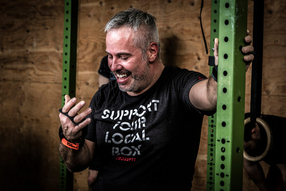 Homme en sueur récupérant après une exercice dans un cours de Crossfit