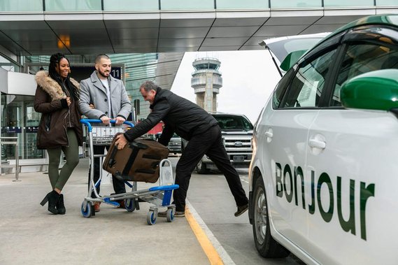 Transport vers les aéroports, service offert par Taxi COOP  couple descendant d'un taxi  et chauffeur sortant leurs valises