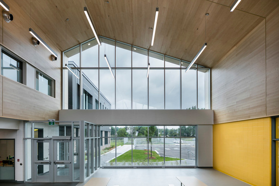 École située dans le nrd de Montréal, montrant sa fenestration généreuse, son stationnement