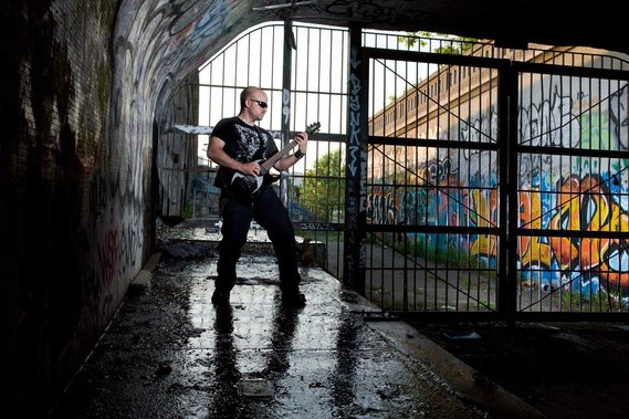 Environmental portrait of a guitarist in a trash city surrounding
