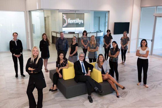 Corporate group portrait of employees standing at the reception area of their offices