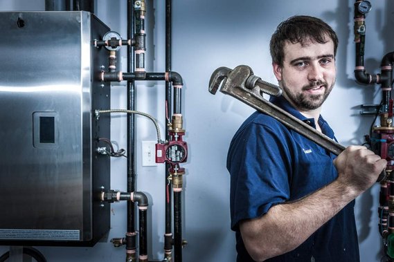 Editorial portrait of a plumber posing at work with his tools