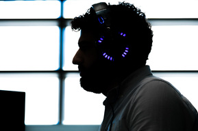 Employé d'une entreprise en technologies de l'information photographié en silhouette avec des écouteurs sur les oreilles