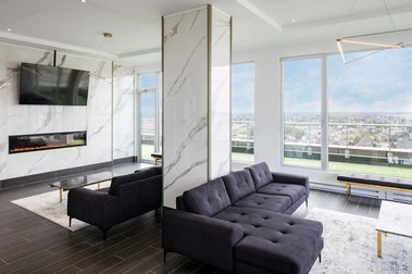 Projet de condos Marquise Phase 3 à Laval montrant le chalet un salon vitré avec foyer et télé au mur