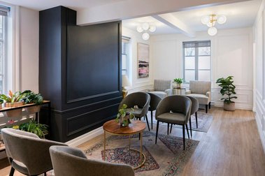 Vue d'une salle d'attente dans une clinique médicale, fauteuils individuels, tapis, tables à café, boiseries typiques d'une maison historique