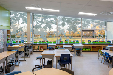 Classe de l'école Saint-Rémi à ville Mercier montrant son aménagement intérieur  ainsi que les grandes fenêtres extérieures où apparaissent des motifs de feuilles