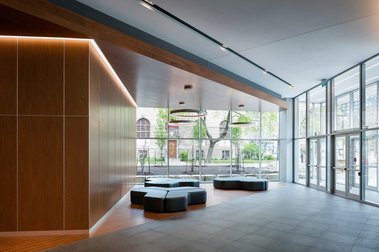 Lobby de l'édifice à bureaux au 1100 Atwater à Montreal, grands murs de bois, éclairage au néon, grandes vitrines donnant sur la rue 